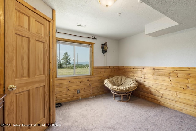 188 E 3000 S, Driggs, ID 83422 - living area with carpet flooring, a textured ceiling, wood walls, and wainscoting