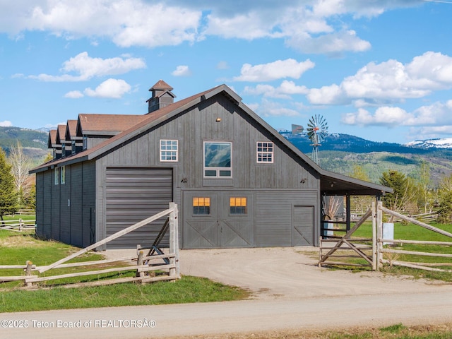 6827 S 1750 W, Victor, ID 83455 - rustic home with an outdoor structure, a barn, dirt driveway, and a mountain view