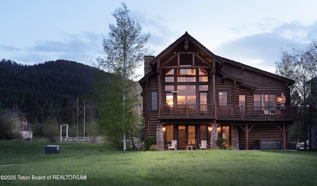 88 Blackfoot Trl, Victor, ID 83455 - back of house featuring log siding, a lawn, and a wooden deck