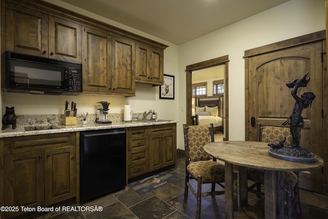 88 Blackfoot Trl, Victor, ID 83455 - kitchen with black appliances, dark stone finish floors, light stone counters, dark brown cabinetry, and a sink