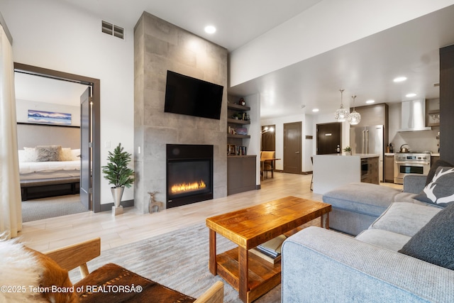 150 W Simpson Ave Unit 405, Jackson, WY 83011 - living room featuring a fireplace, recessed lighting, light wood-type flooring, a chandelier, and baseboards