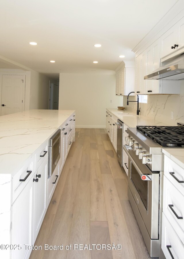 755 Cache Creek Dr, Jackson, WY 83001 - kitchen with appliances with stainless steel finishes, white cabinets, light wood finished floors, light stone countertops, and recessed lighting