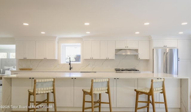 755 Cache Creek Dr, Jackson, WY 83001 - kitchen with stainless steel fridge, under cabinet range hood, decorative backsplash, white cabinetry, and recessed lighting