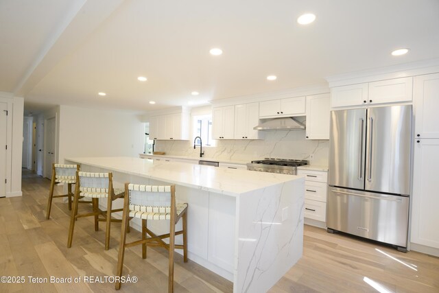 755 Cache Creek Dr, Jackson, WY 83001 - kitchen with freestanding refrigerator, under cabinet range hood, a large island, light wood-style floors, and recessed lighting