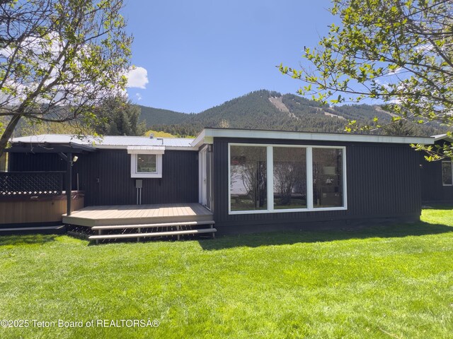 755 Cache Creek Dr, Jackson, WY 83001 - rear view of house featuring a deck with mountain view and a lawn