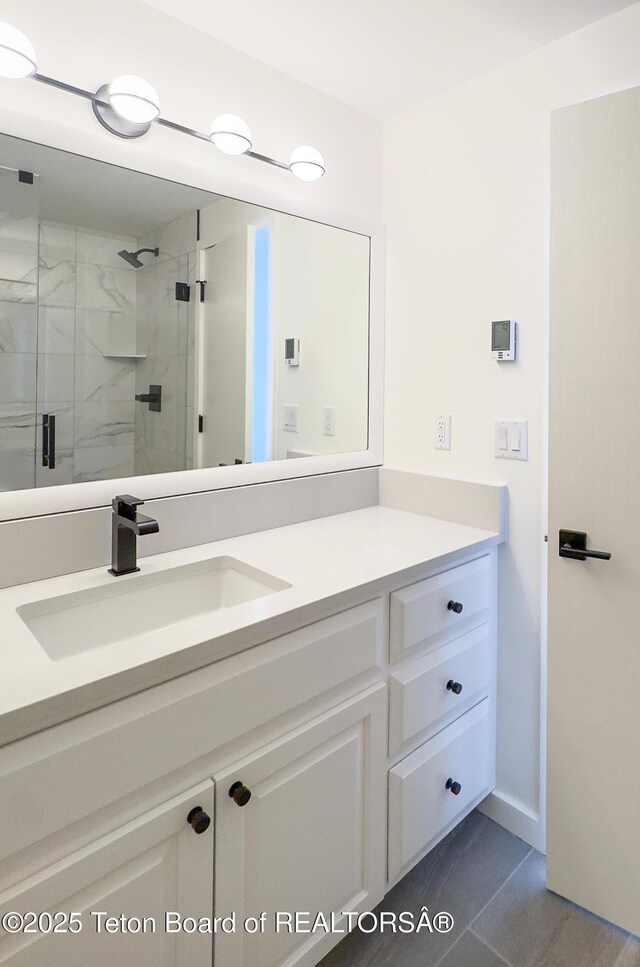 755 Cache Creek Dr, Jackson, WY 83001 - bathroom with vanity, a marble finish shower, tile patterned floors, and baseboards