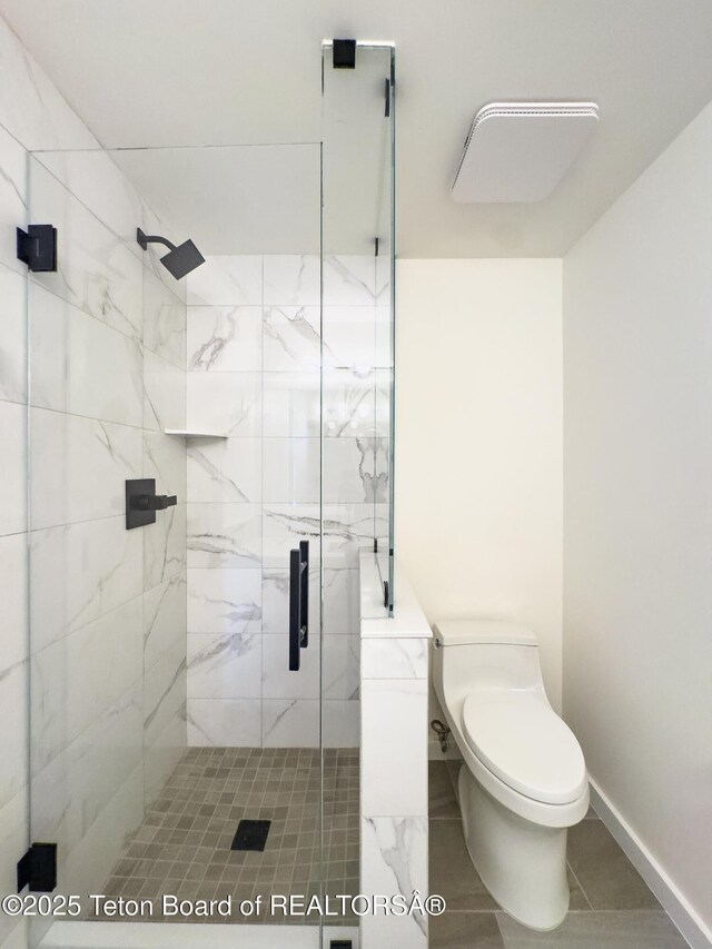 755 Cache Creek Dr, Jackson, WY 83001 - full bath with a marble finish shower, toilet, baseboards, and tile patterned flooring