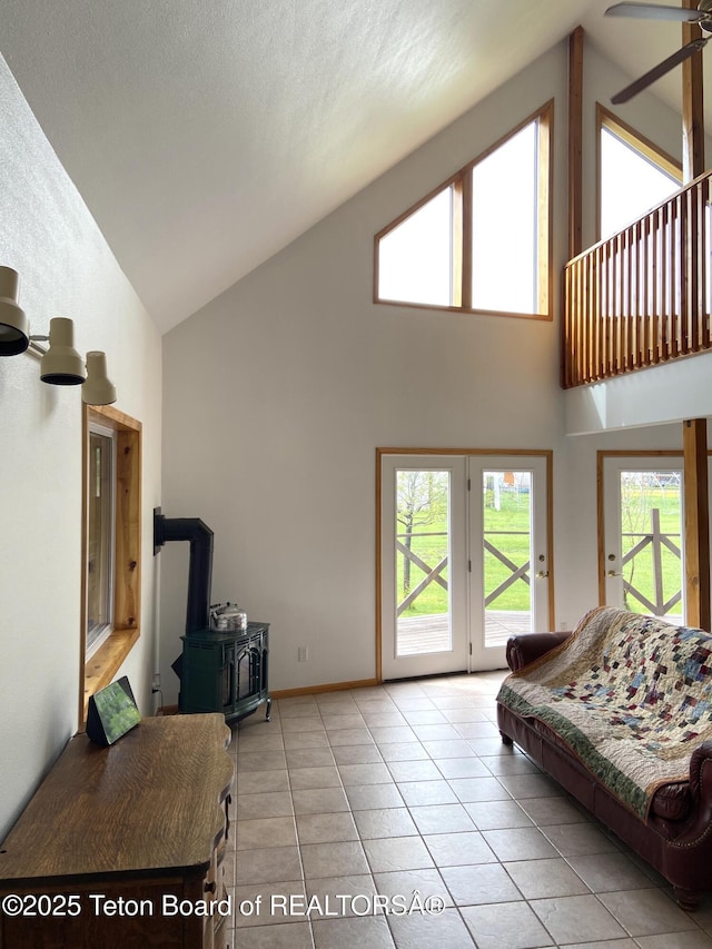 522 El Clark Ln, Smoot, WY 83126 - living room with high vaulted ceiling, a wood stove, ceiling fan, and tile patterned floors