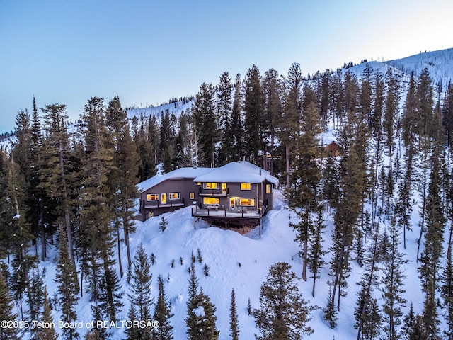 6960 Lupine Trl, Wilson, WY 83001 - snowy aerial view featuring a wooded view and a mountain view