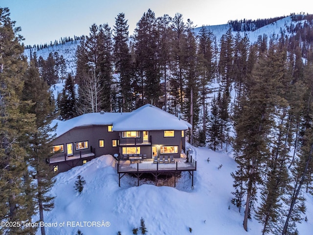 6960 Lupine Trl, Wilson, WY 83001 - view of front of property with a wooded view and a deck with mountain view