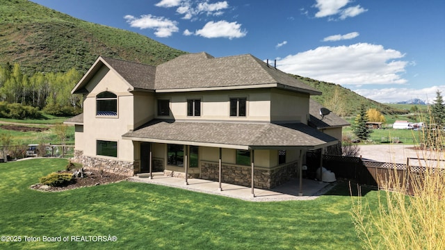 33 Wagon Rut Ln, Auburn, WY 83111 - back of property featuring stucco siding, stone siding, and a patio area