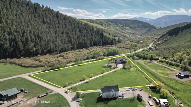 33 Wagon Rut Ln, Auburn, WY 83111 - aerial view of property's location with a mountainous background, property parcel outlined, and a forest