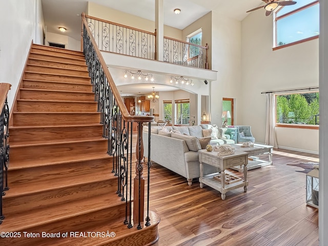 33 Wagon Rut Ln, Auburn, WY 83111 - living room with stairway, wood finished floors, a chandelier, a ceiling fan, and a high ceiling