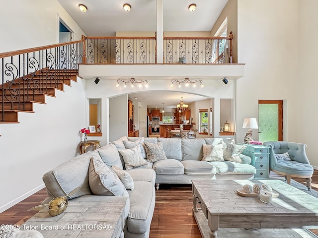 33 Wagon Rut Ln, Auburn, WY 83111 - living area with a chandelier, wood finished floors, a high ceiling, stairway, and arched walkways