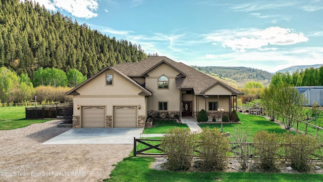 33 Wagon Rut Ln, Auburn, WY 83111 - view of front of house with stucco siding, stone siding, driveway, and a mountain view