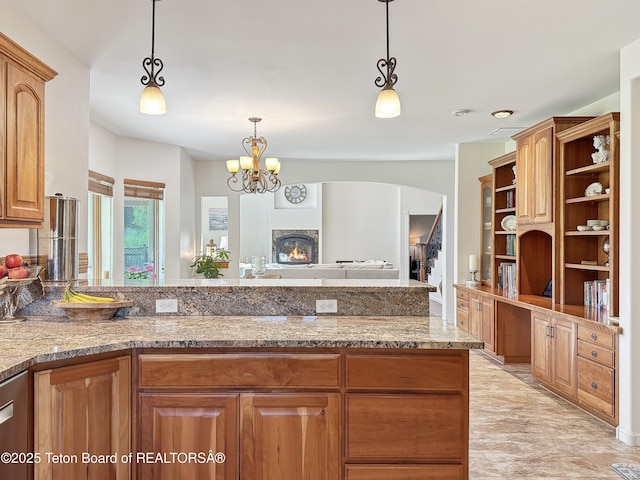 33 Wagon Rut Ln, Auburn, WY 83111 - kitchen with open shelves, light stone countertops, a lit fireplace, decorative light fixtures, and a peninsula