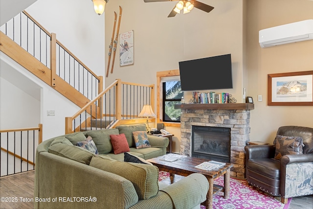 371 Snow King Loop, Jackson, WY 83001 - living area with wood finished floors, a wall mounted AC, a towering ceiling, a ceiling fan, and a fireplace