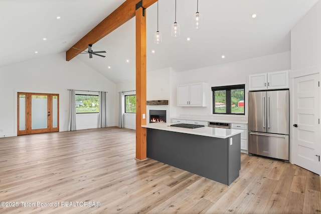 185 Columbine St, Alpine, WY 83128 - kitchen featuring high quality fridge, gas stovetop, light countertops, white cabinetry, and beam ceiling