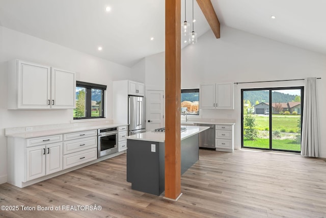 185 Columbine St, Alpine, WY 83128 - kitchen featuring stainless steel appliances, high vaulted ceiling, beam ceiling, white cabinetry, and light countertops