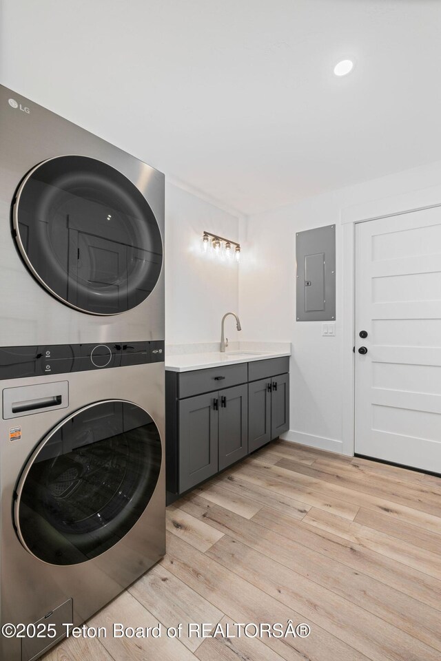 185 Columbine St, Alpine, WY 83128 - laundry room with stacked washer / drying machine, electric panel, cabinet space, light wood-style floors, and recessed lighting