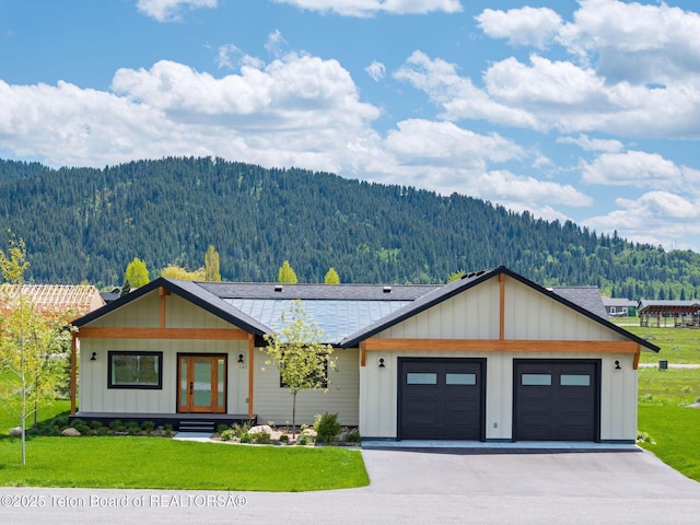 185 Columbine St, Alpine, WY 83128 - modern farmhouse featuring a forest view, a front lawn, a mountain view, and an attached garage