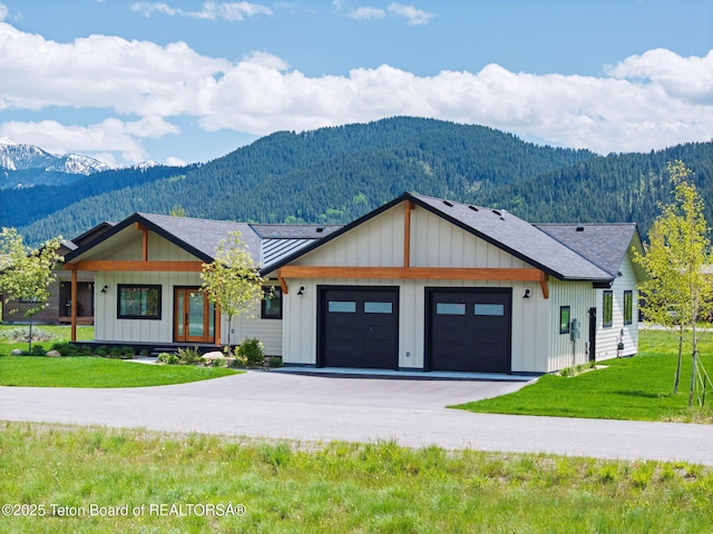185 Columbine St, Alpine, WY 83128 - modern inspired farmhouse with a mountain view, driveway, an attached garage, and board and batten siding