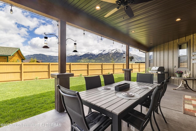 444 Riverview Dr, Alpine, WY 83128 - view of patio with outdoor dining area, a mountain view, ceiling fan, and area for grilling