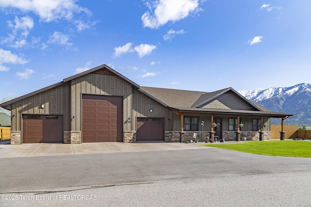 444 Riverview Dr, Alpine, WY 83128 - view of front of house featuring stone siding, a mountain view, board and batten siding, and a front yard