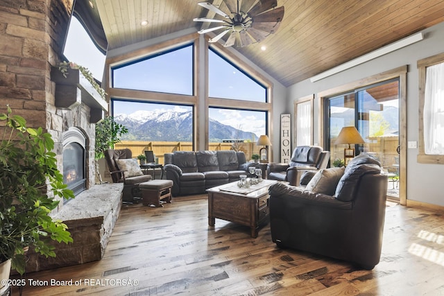 444 Riverview Dr, Alpine, WY 83128 - living room with ceiling fan, healthy amount of natural light, wood ceiling, a mountain view, and a glass covered fireplace