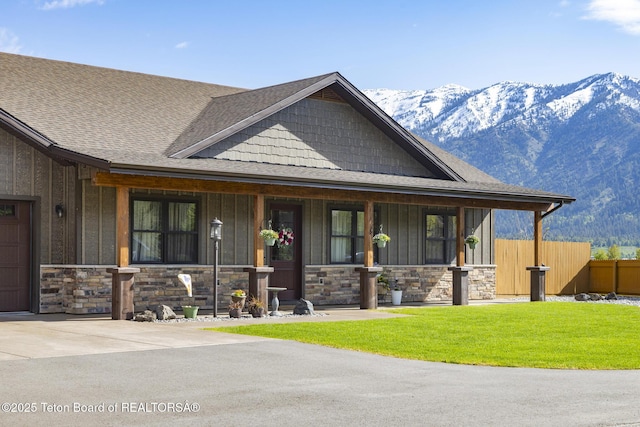 444 Riverview Dr, Alpine, WY 83128 - view of front of home with a porch, a mountain view, a shingled roof, and stone siding