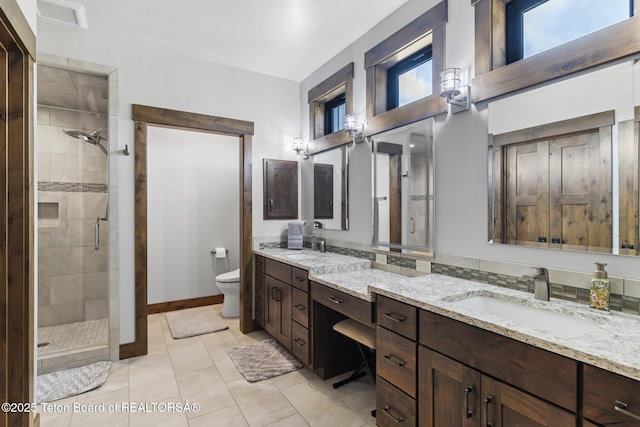 444 Riverview Dr, Alpine, WY 83128 - full bathroom with double vanity, a stall shower, toilet, tile patterned floors, and baseboards
