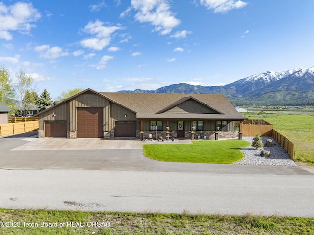 444 Riverview Dr, Alpine, WY 83128 - view of front of property featuring stone siding, a mountain view, driveway, and an attached garage