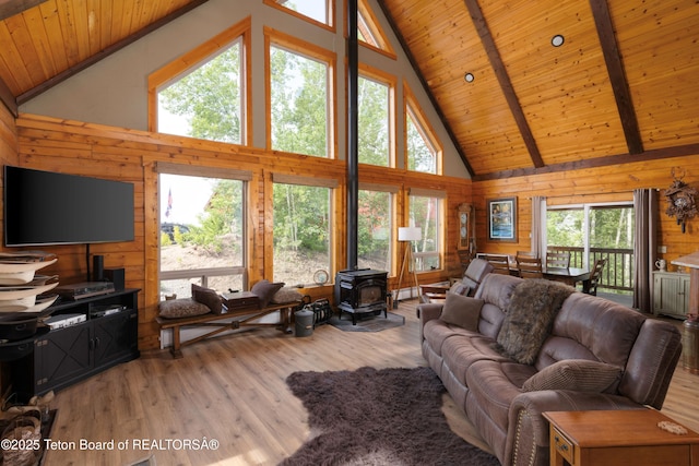 57 Lynx Trl, Alpine, WY 83128 - living area with a wood stove, high vaulted ceiling, wood walls, healthy amount of natural light, and wood finished floors