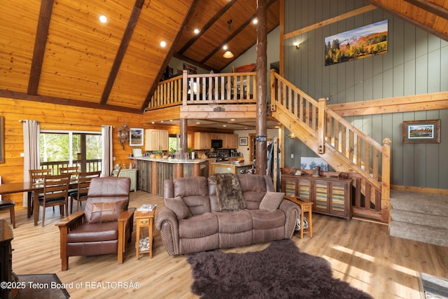 57 Lynx Trl, Alpine, WY 83128 - living room with high vaulted ceiling, stairs, light wood-type flooring, wooden ceiling with exposed beams, and wooden walls