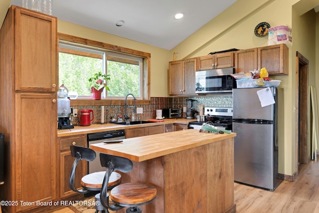 57 Lynx Trl, Alpine, WY 83128 - kitchen featuring stainless steel appliances, butcher block countertops, a sink, vaulted ceiling, and tasteful backsplash
