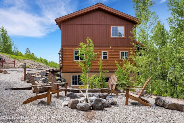 57 Lynx Trl, Alpine, WY 83128 - rear view of property with log exterior and an outdoor fire pit