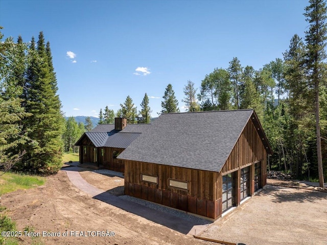 5727 Forest Ridge Rd, Victor, ID 83455 - view of front of house featuring a shingled roof, a detached garage, and driveway