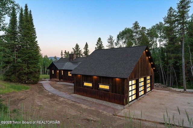 5727 Forest Ridge Rd, Victor, ID 83455 - view of front facade with a detached garage, a shingled roof, and a chimney