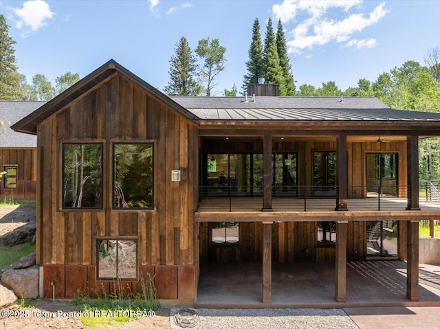 5727 Forest Ridge Rd, Victor, ID 83455 - rear view of property featuring board and batten siding, a shingled roof, a chimney, and a standing seam roof