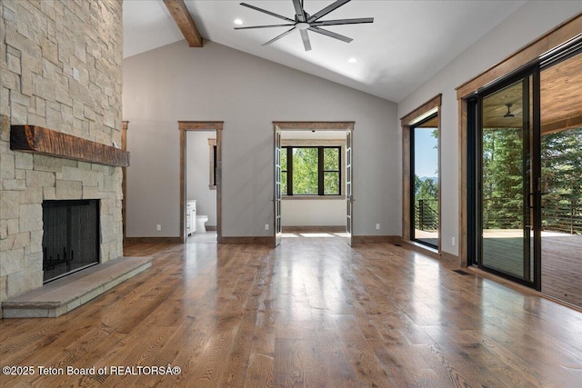 5727 Forest Ridge Rd, Victor, ID 83455 - unfurnished living room featuring beamed ceiling, high vaulted ceiling, wood finished floors, a fireplace, and a ceiling fan
