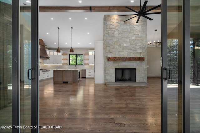 5727 Forest Ridge Rd, Victor, ID 83455 - unfurnished living room with beamed ceiling, dark wood finished floors, a fireplace, recessed lighting, and ceiling fan