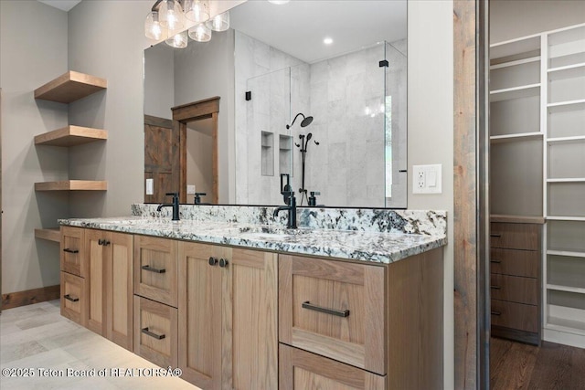 5727 Forest Ridge Rd, Victor, ID 83455 - bathroom with double vanity, a walk in closet, a tile shower, and wood finished floors