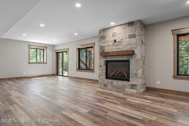 5727 Forest Ridge Rd, Victor, ID 83455 - unfurnished living room with wood finished floors, healthy amount of natural light, a stone fireplace, and recessed lighting