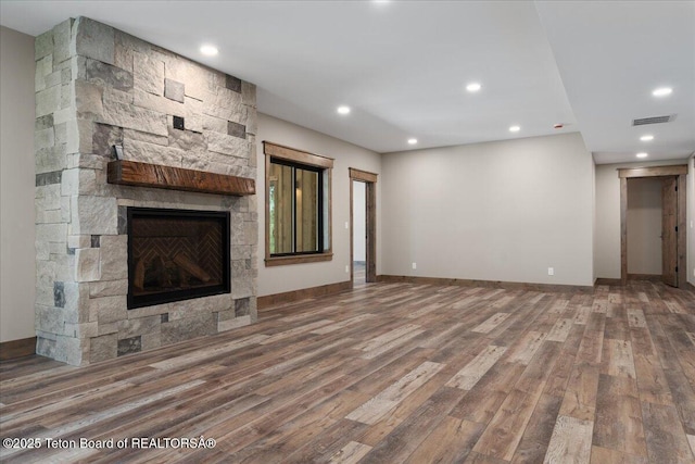 5727 Forest Ridge Rd, Victor, ID 83455 - unfurnished living room with wood finished floors, a stone fireplace, and recessed lighting