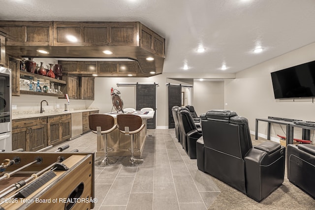 405 Vista Dr, Star Valley Ranch, WY 83127 - kitchen featuring a barn door, stainless steel dishwasher, light countertops, open floor plan, and a sink
