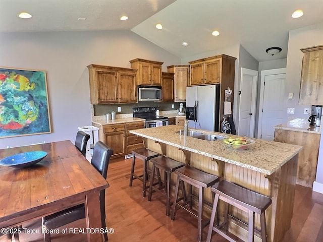 461 Booshway St, Driggs, ID 83422 - kitchen with stainless steel microwave, electric range, fridge with ice dispenser, vaulted ceiling, and brown cabinetry