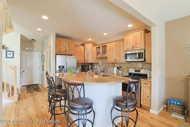 165 Cobble Creek Ln, Driggs, ID 83422 - kitchen featuring appliances with stainless steel finishes, a breakfast bar, light wood-style flooring, baseboards, and recessed lighting