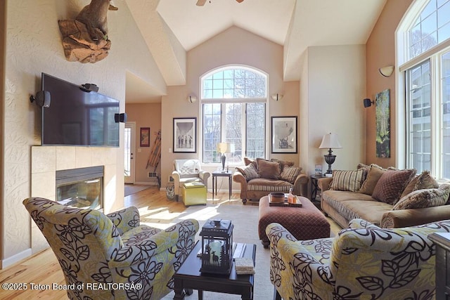 165 Cobble Creek Ln, Driggs, ID 83422 - living area featuring light wood-type flooring, high vaulted ceiling, a tile fireplace, and a ceiling fan