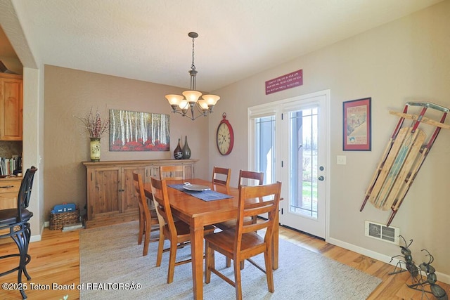 165 Cobble Creek Ln, Driggs, ID 83422 - dining area featuring light wood-style floors, a chandelier, and baseboards