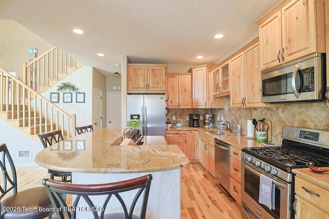 165 Cobble Creek Ln, Driggs, ID 83422 - kitchen with appliances with stainless steel finishes, light brown cabinetry, light wood-style floors, recessed lighting, and a textured ceiling